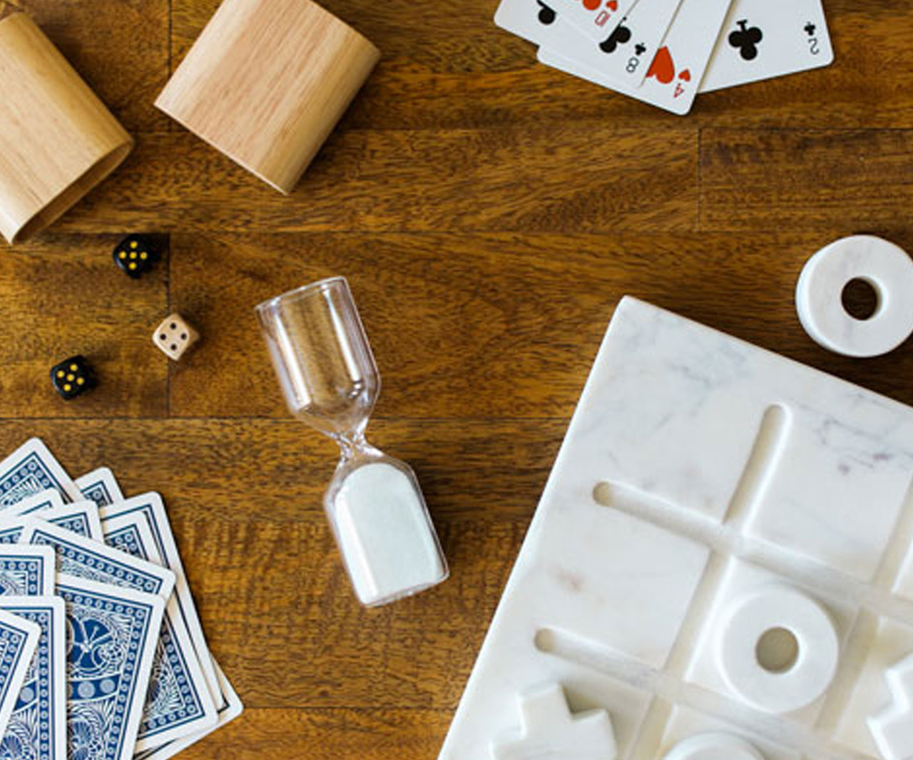 Table with dice, cards and a timer on it.