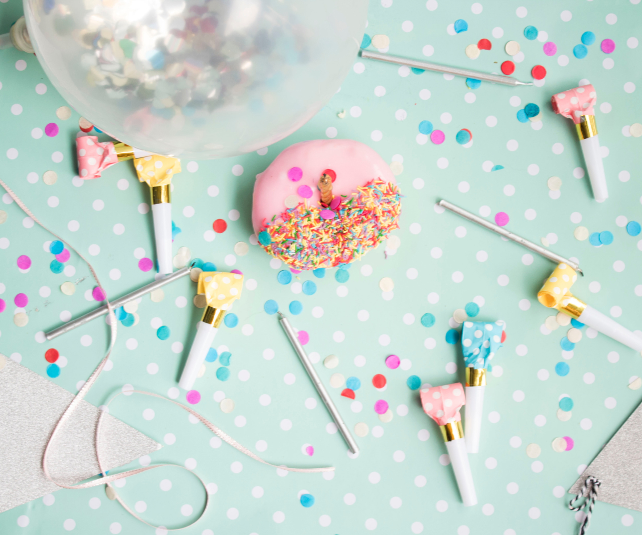 Overhead shot of table covered in confetti and party blowers.