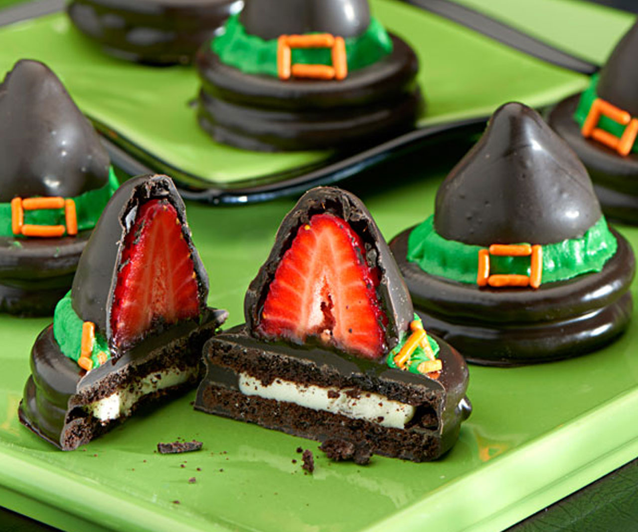 OREO cookies topped with strawberries and chocolate to look like hats.