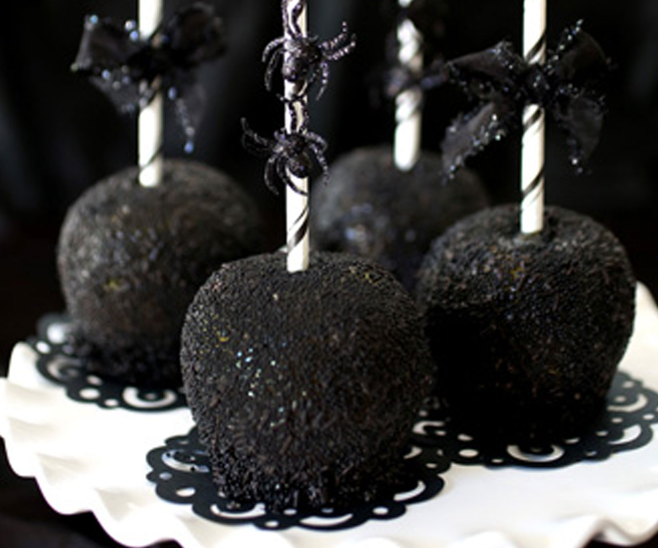 Spooky caramel apples with black sugar coating.