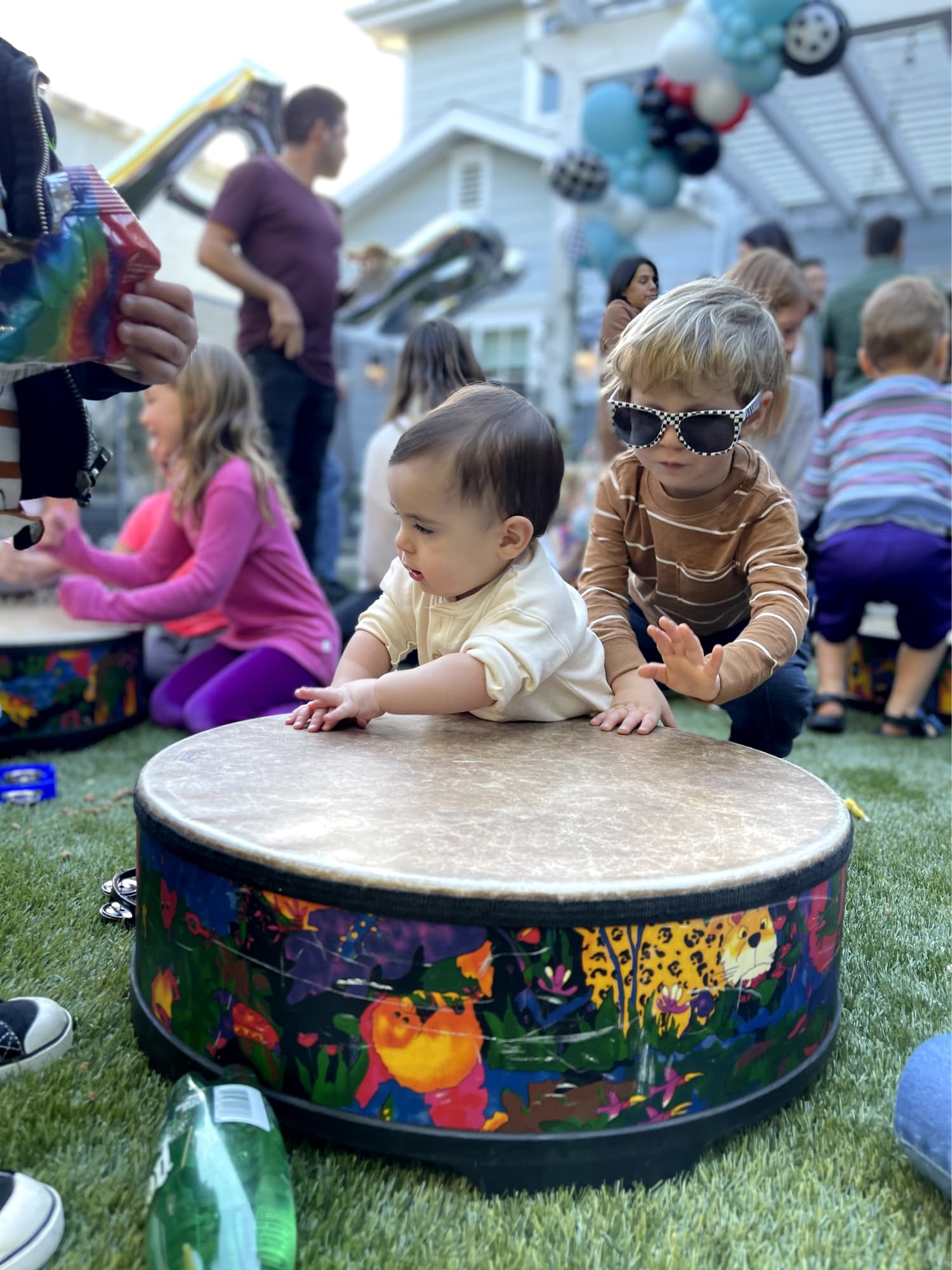 Babies playing with a drum.