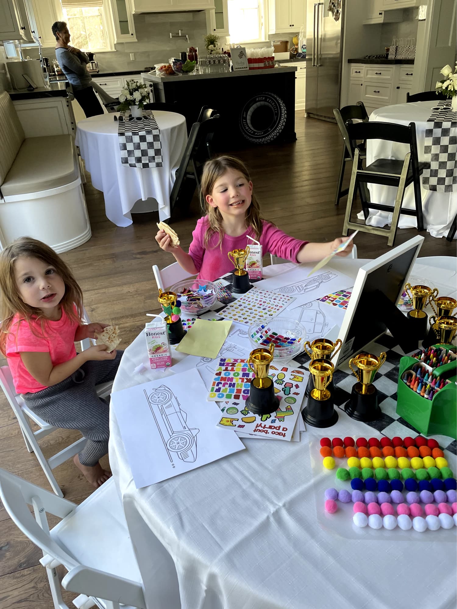 Kids at a craft station coloring in cars.