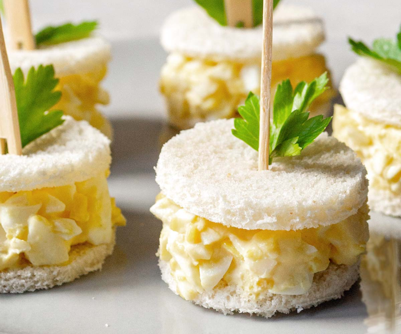 A close-up of egg salad finger sandwiches.