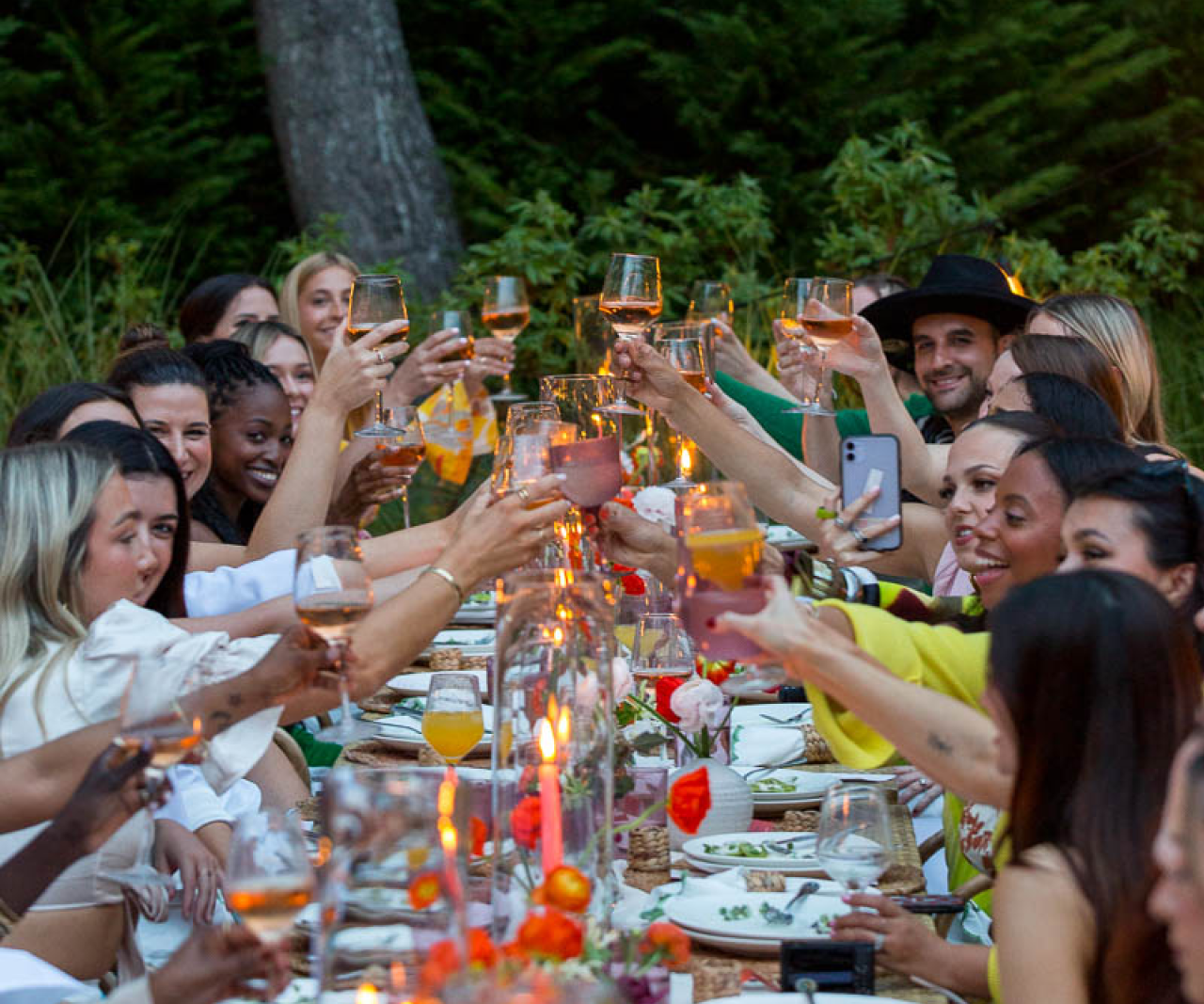 A long table full of people lifting their glasses.