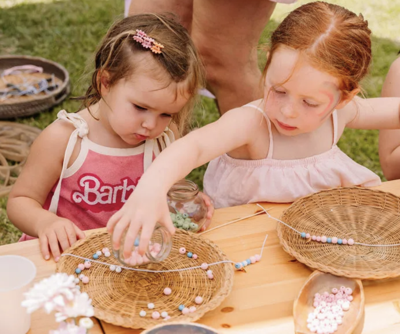 Kids making crafts with beads.