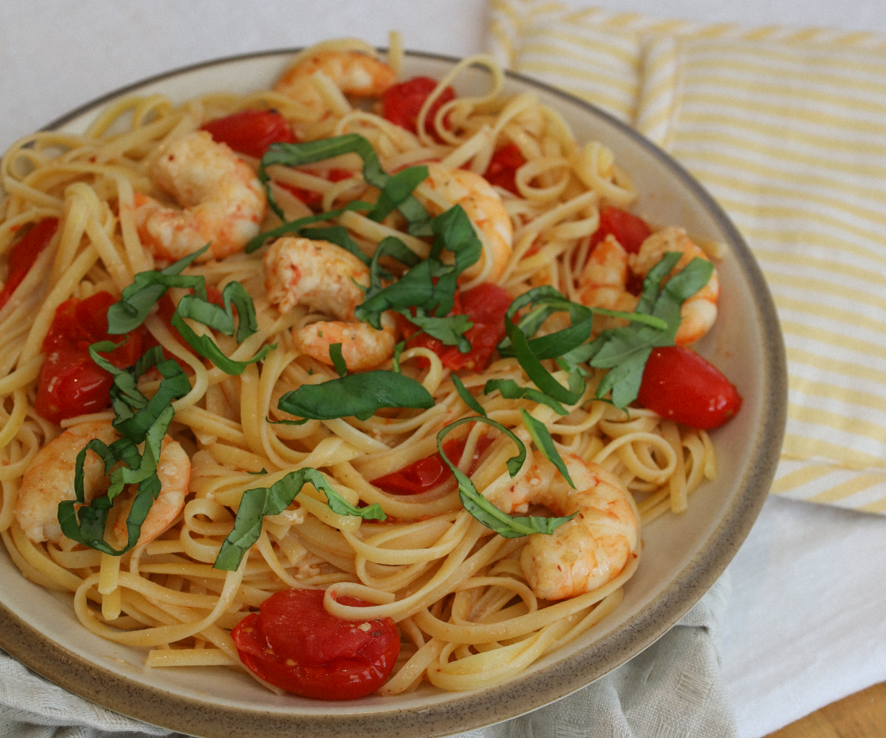 Bowl of linguine with shrimp and cherry tomatoes.