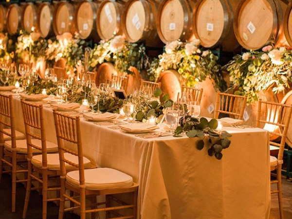 Wedding table in front of wine barrels (image from Pinterest).