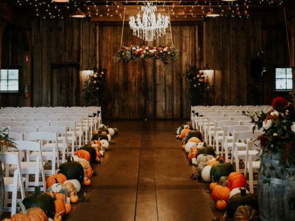 Wedding aisle in a barn with pumpkins lining the path (image from Pinterest).