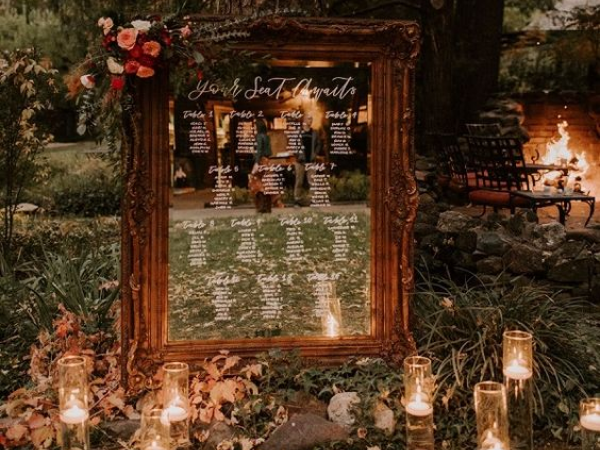 Framed mirror with table settings on it surrounded by candles outdoors (image from Pinterest).