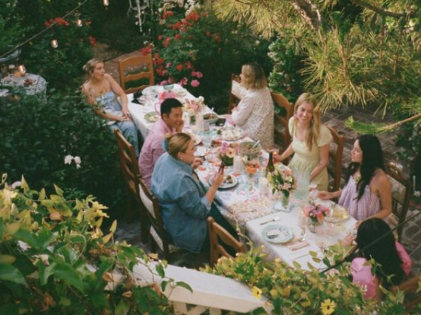 People sitting together in a beautiful backyard.