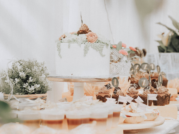 Dessert table with cake, cupcakes and more sweets.